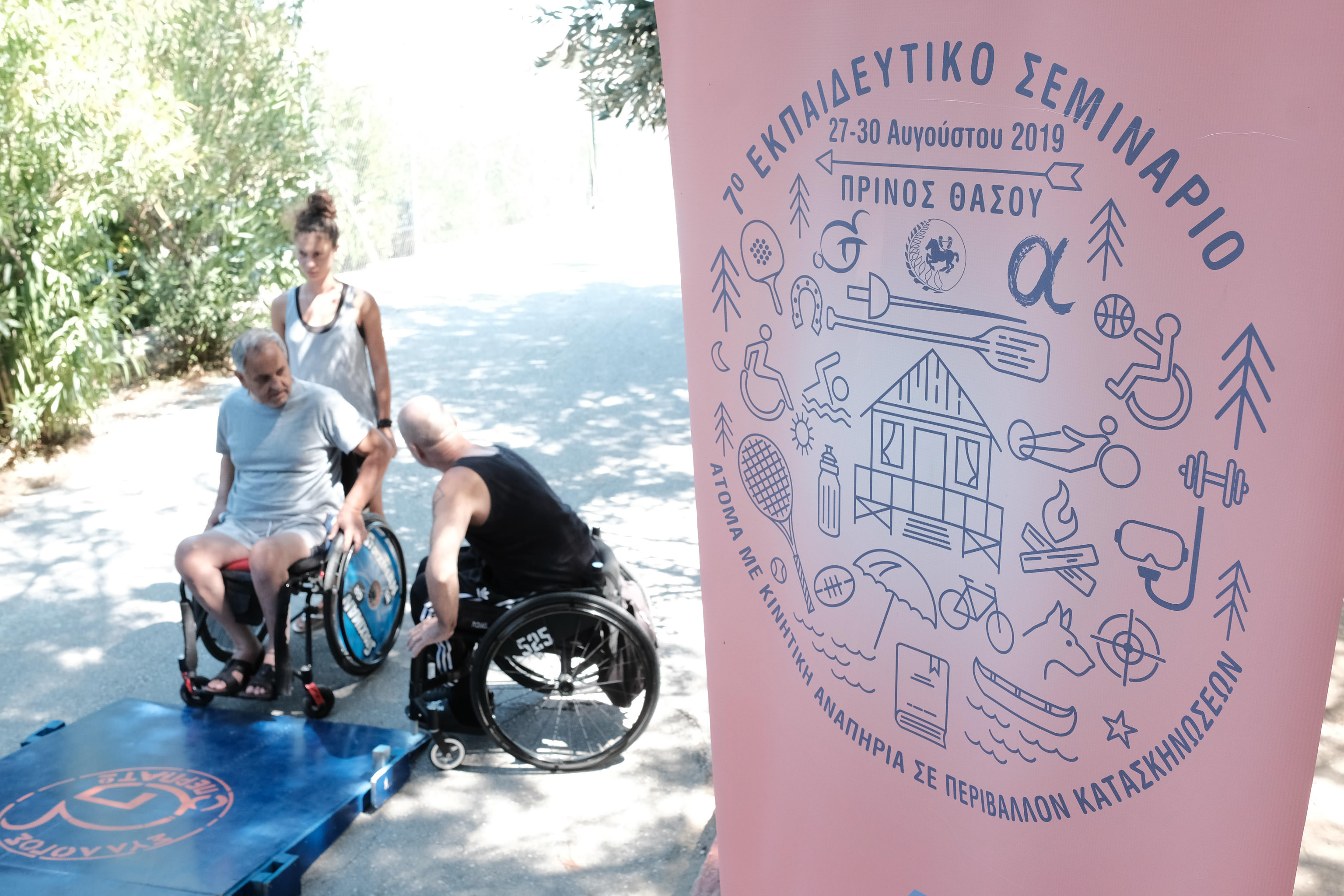 Cover. On the left, two male wheelchair users and a non-disabled female talking. On the right, a banner with a logo of multiple drawings of outdoor activities and a title: 7th training camp for disabled people with mobility impairments. August 2019