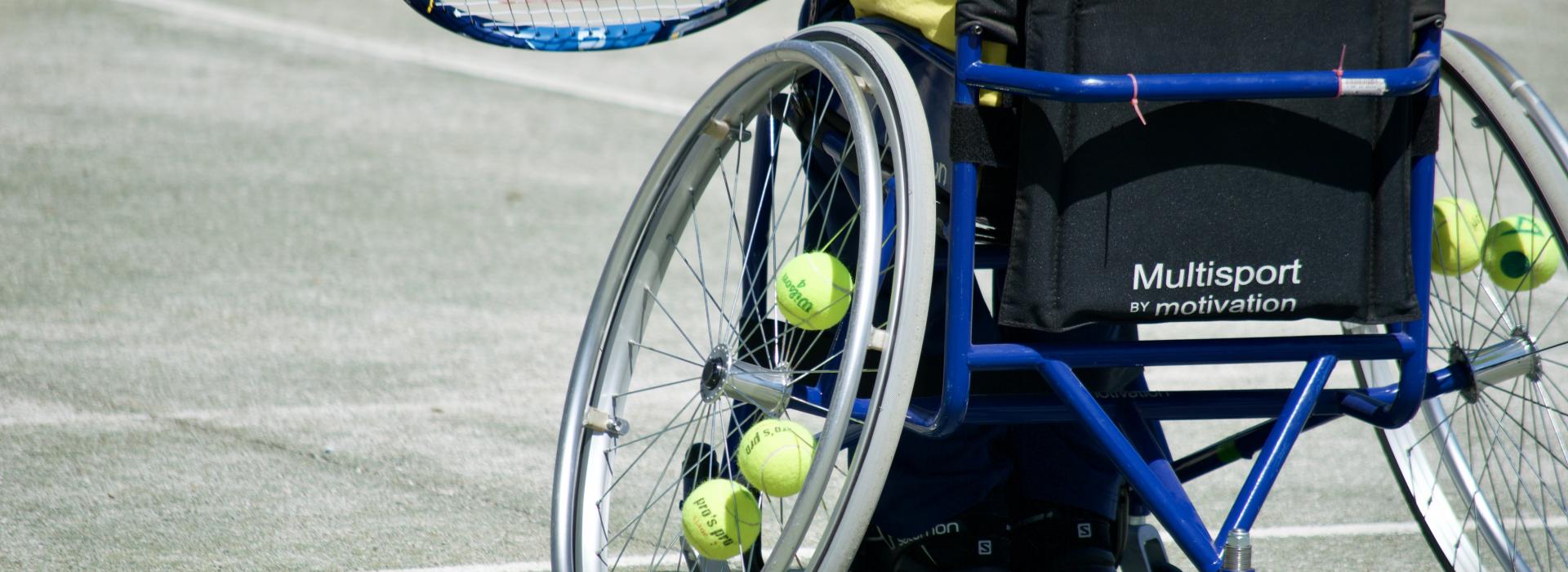 Cover. Tennis Court. Back of a tennis wheelchair in action.